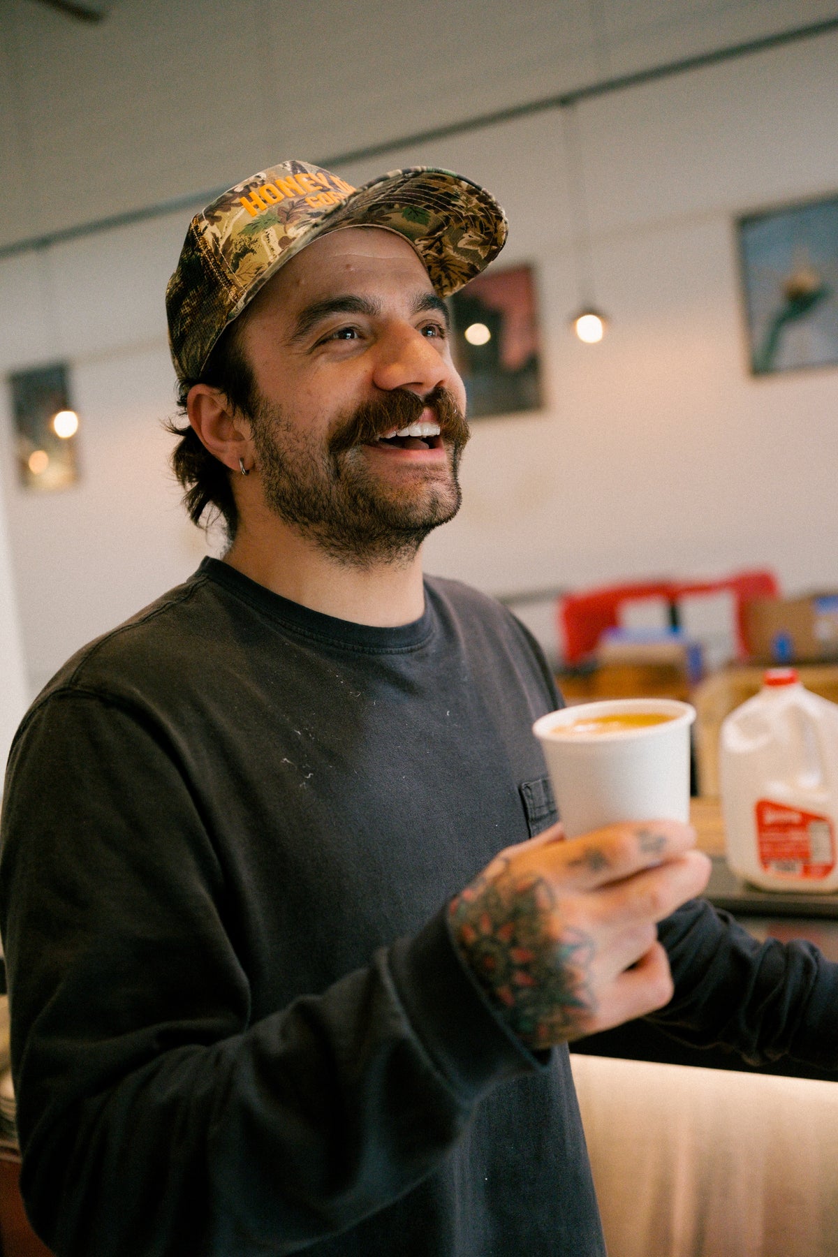 Honey Dirt Coffee owner smiling with a coffee in the café